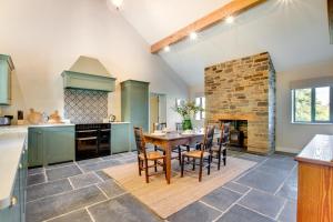a kitchen with a table and a stone fireplace at 2 Bed in Builth Wells oc-bow198 in Builth Wells