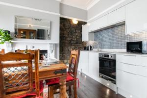 a kitchen with white cabinets and a wooden table at 2 Bed in Langland oc-hh142 in Newton +12 photos
