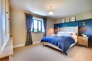 a bedroom with a bed with a blue headboard and a window at 2 Bed in Builth Wells oc-bow198 in Builth Wells