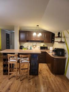 a kitchen with wooden cabinets and a table and chairs at Apartament Kleopatra in Limanowa