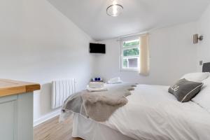 a white bedroom with a bed with a blanket on it at 2 Bed in Caswell Bay oc-hh379 in Newton