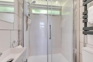 a white bathroom with a shower and a sink at 2 Bed in Caswell Bay oc-hh379 in Newton