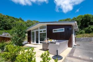 a tiny house with a patio and a table at 2 Bed in Caswell Bay oc-hh379 in Newton