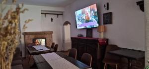 a room with a table and a tv on the wall at Vila Studio Rasnov cu ciubar si sauna in Râşnov