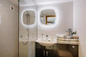 a bathroom with a sink and a shower with mirrors at 2 Bed in Lixwm oc-bow179 in Halkyn +20 photos
