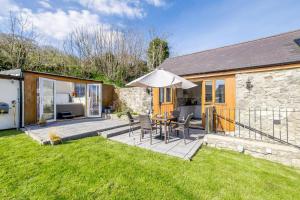 a patio with an umbrella and a table and chairs at 2 Bed in Lixwm oc-bow179 in Halkyn