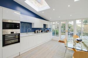 a kitchen with white cabinets and a glass table at 3 Bed in Beer oc-jbvalh in Beer