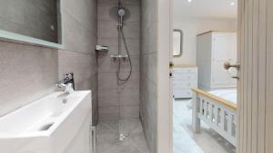 a white bathroom with a shower and a sink at 3 Bed in Llanbedrog oc-llynor in Llanbedrog +25 photos