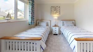 two twin beds in a room with a window at 3 Bed in Llanbedrog oc-llynor in Llanbedrog