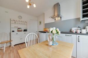 a kitchen with a table with a vase of flowers on it at 2 Bed in Seaton oc-mbbri in Seaton