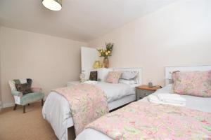 a bedroom with two beds and a chair at 4 Bed in Seaton oc-s27403 in Seaton