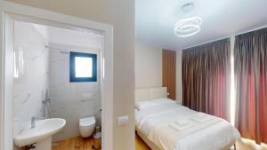 a bedroom with a bed and a sink and a bathroom at Vila MUJE in Belsh +81 photos