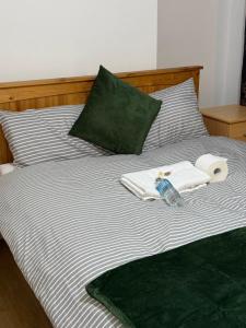 a bed with towels and a bottle of water on it at Exquisite King-sized Bedroom - Free Parking in Dartford