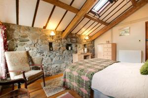 a bedroom with a bed and a stone wall at 2 Bed in Caernarfon oc-wag263 in Llandegfan