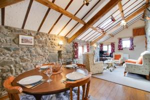 a dining room with a table and a stone wall at 2 Bed in Caernarfon oc-wag263 in Llandegfan