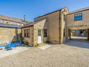 a brick house with a garage and blue chairs at 2 Bed in Sedbergh oc-89266 in Milnthorpe