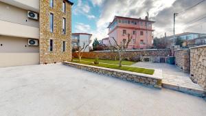 a building with a stone wall and a courtyard at Vila MUJE in Belsh
