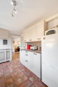 a kitchen with white cabinets and a tile floor at 3 Bed in Docking oc-1837 in Docking