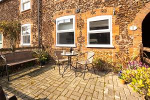 a patio with chairs and a table in front of a building at 3 Bed in Docking oc-1837 in Docking +5 photos