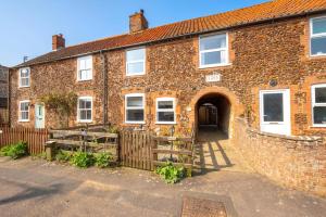 an old brick house with a gate in front of it at 3 Bed in Docking oc-1837 in Docking