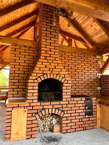 an outdoor brick oven with a wooden ceiling at Carpathic Chalet in Comandău