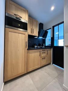 a kitchen with wooden cabinets and a sink at Studio face plage / centre ville in Arcachon +9 photos