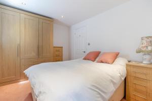 a bedroom with a white bed with two orange pillows at 1 Bed in Halam oc-o32227 in Edingley