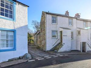 an old stone house with blue windows on a street at 2 Bed in Cockermouth oc-86023 in Lorton