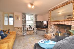a living room with a stone fireplace and a mirror at 2 Bed in Seaton oc-b27402 in Seaton