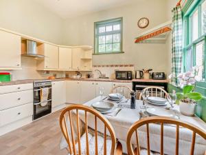 a kitchen with a table and chairs and a kitchen with white cabinets at 2 Bed in Alford oc-94226 in Great Carlton