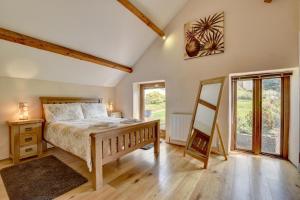 a bedroom with a bed and a wooden floor at 2 Bed in Tiverton oc-cide in Bampton