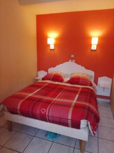 a bedroom with a bed with a red wall at RESIDENCE du NEPTUNE in Saint-Cyprien-Plage +1 photo
