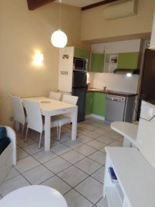 a kitchen with a table and a white table and chairs at RESIDENCE du NEPTUNE in Saint-Cyprien-Plage