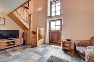 a living room with a television and a staircase at 2 Bed in Tiverton oc-cide in Bampton