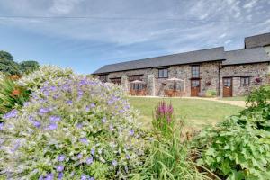 a stone house with a garden and flowers at 2 Bed in Tiverton oc-cide in Bampton
