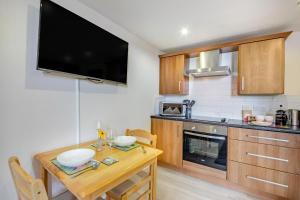 a kitchen with a wooden table and a tv on the wall at 1 Bed in Berwick-upon-Tweed oc-a32026 in Kyloe +13 photos