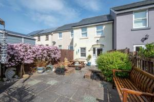 a backyard with a wooden bench and a house at 2 Bed in Seaton oc-mbtuc in Seaton