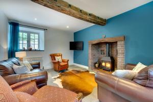 a living room with leather furniture and a fireplace at 4 Bed in Ruthin oc-bow136 in Gwyddelwern