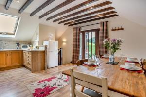 a kitchen and dining room with a wooden table and chairs at 2 Bed in Trallong oc-bow106 in Sennybridge