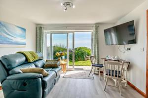 a living room with a blue couch and a table with chairs at 1 Bed in Blue Anchor oc-b28904 in Blue Anchor