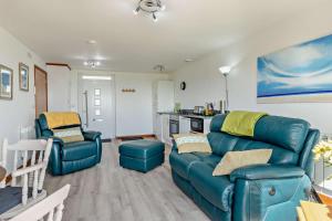 a living room with a blue couch and two chairs at 1 Bed in Blue Anchor oc-b28904 in Blue Anchor +10 photos