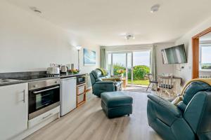 a kitchen with two blue chairs and a living room at 1 Bed in Blue Anchor oc-b28904 in Blue Anchor