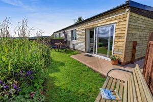 a wooden house with a bench in the yard at 1 Bed in Blue Anchor oc-b28904 in Blue Anchor