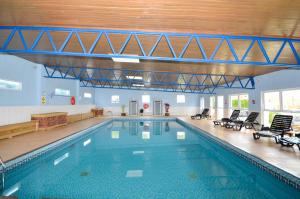 a large swimming pool with chairs in a building at 2 Bed in Brixham oc-f28884 in Brixham