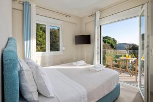 a bedroom with a bed and a balcony with a television at Thalia by Vintage Travel in Agios Georgios +31 photos