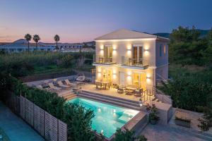 a house with a swimming pool in front of it at Thalia by Vintage Travel in Agios Georgios
