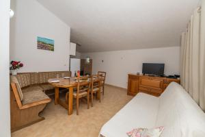 a living room with a table and chairs and a television at Holiday house Marijana in Zagvozd