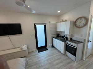 a kitchen with a clock on the wall and a stove at Central location in Cutler Bay