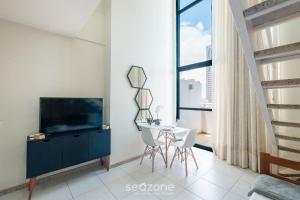 a living room with a television and a table and chairs at Studio w/ pool & barbecue in the building RAQ1609 in Salvador