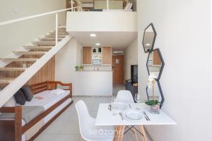 a living room with a table and a staircase at Studio w/ pool & barbecue in the building RAQ1609 in Salvador